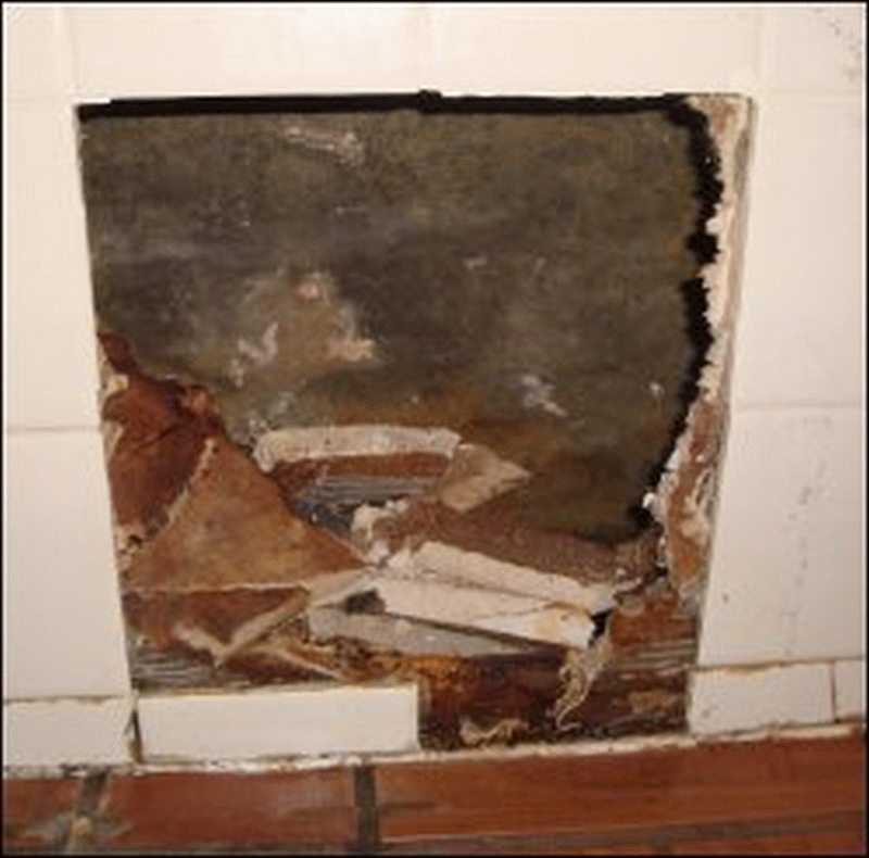 A phto of the broken wall just inside the door of Shower 5 at the Sunbury, OH, Pilot Travel Center. Tiles are broken out showing the interior of the wall. This is not only unsightly but can be dangerous.