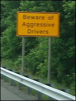 A sign that reads 'Beware of Aggressive Drivers'
