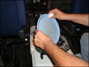 Mike washes dishes in his big truck. Even though a chore, he saved big money by eating a home cooked meal in his truck.