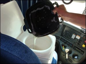 Dumping dirty dish washing water into our portable toilet. The toilet was depository for waste wash water until we dumped it.