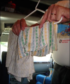 Drying out a dishcloth and dish towel in a large truck after washing dishes in a created small kitchen.