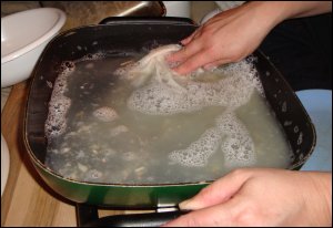 Vicki washes dishes in an electric skillet in a semi tractor trailer.