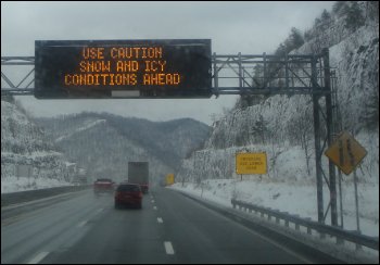 Road sign showing snow and icy conditions ahead.