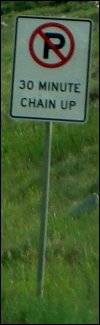 Close-up of tire chain up station sign along I-70 in Colorado.