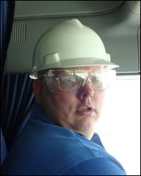 Professional driver Mike Simons sports a hard hat and safety glasses that he had to wear at one shipper's facility.