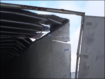 Roof and rear door damage on the back of a trailer.