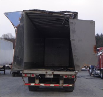 Roof and rear door damage on the back of a trailer.