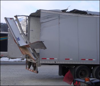 Roof and rear door damage on the back of a trailer.