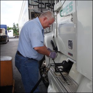 Mike Simons puts fuel from a fuel pump into his truck.