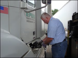 Mike Simons puts fuel from a fuel pump into his truck.