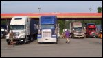 Trucks at a truckstop, in or pulled through the fuel bay where they pumped fuel at the fuel pump.