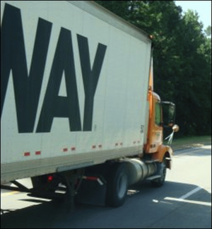 A daycab tractor pulls a long trailer.