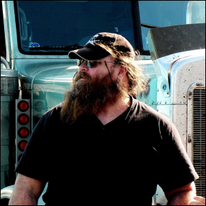 A veteran truck driver outside the truck he drives for a living.