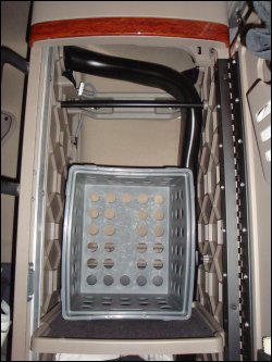 A rectangular plastic crate used for truck organization in the cabinet behind the driver's seat.