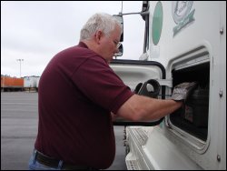 Professional truck driver Mike Simons reaches into the side box on the driver's side of his truck to get a tool that was stored under his bunk.
