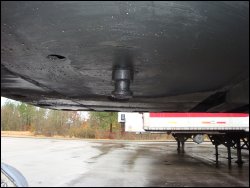 A side view of the underside of a trailer and its kingpin after the tractor had been pulled out.