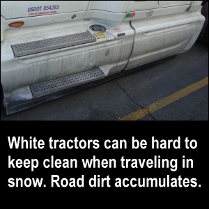 White tractors can be hard to keep clean when traveling in snow. Road dirt accumulates.