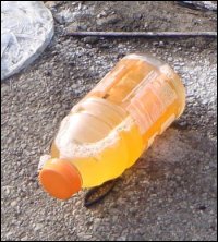 A plastic bottle filled with urine, otherwise known as a trucker bomb, sitting in a truck stop parking lot.