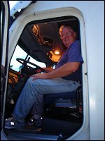 Professional driver Mike Simons sits in the driver's seat of his company truck.