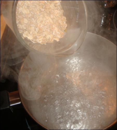 Vicki prepares to pour measured multi grain cereal into boiling water.