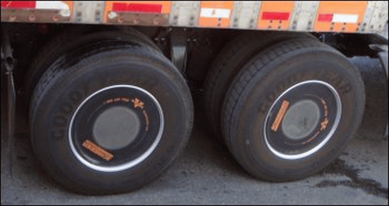 Two drive tires on a Schneider tractor, both of which have aerodynamic wheel covers.